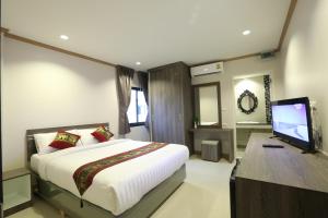 1 dormitorio con 1 cama y TV de pantalla plana en Sunlight Hotel en Jomtien Beach