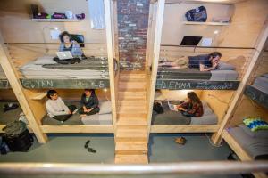 a group of people sitting on bunk beds in a room at PodShare DTLA in Los Angeles