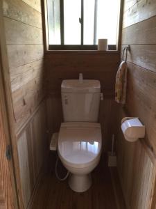a small bathroom with a toilet and a window at Hirauchi Hot Spot in Yakushima