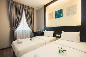 Habitación de hotel con 2 camas y ventana en Hotel CIQ @ Wong Ah Fook, en Johor Bahru