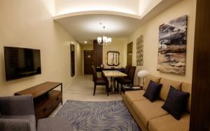 One Central Hotel & Suites في مدينة سيبو: غرفة معيشة مع أريكة وغرفة طعام