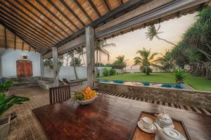 a dining room with a table with a bowl of fruit at Greenparrot-Villa in Ambalangoda