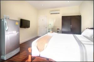 a bedroom with a large white bed and a tv at Wonderful Pool House at Kata in Kata Beach