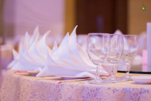 stół z czterema kieliszkami do wina na stole w obiekcie Royal Nakhara Hotel and Convention Centre w mieście Nong Khai