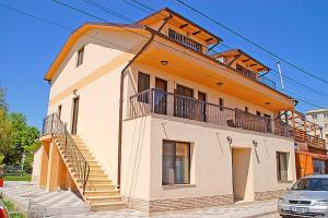 a large building with a balcony and stairs on it at Vila Maritimo in Mangalia