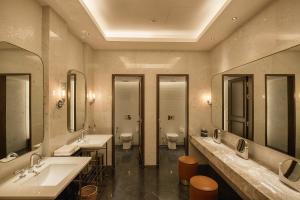uma casa de banho com três lavatórios e dois WC e espelhos em Yangon Excelsior em Yangon