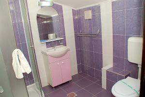 a purple bathroom with a sink and a toilet at Vila Maritimo in Mangalia