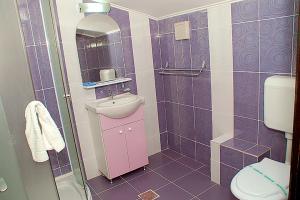 un bagno viola con lavandino e servizi igienici di Vila Maritimo a Mangalia