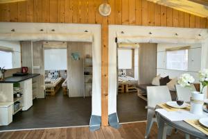 una cucina e una sala da pranzo con pareti in legno e pavimenti in parquet di Glamping Tents - Camp Adriatic a Primošten