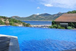 una gran piscina azul con vistas al agua en Stella Marina, en Galeria