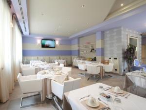 a dining room with white tables and white chairs at Hotel Souvenir in Monterosso al Mare