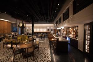 a restaurant with tables and chairs and a clock at Yangon Excelsior in Yangon