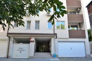 a white building with two garage doors and a ramp at Central Apartment 4 in Stara Zagora