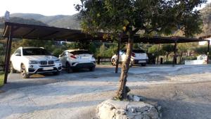 uma garagem com dois carros estacionados debaixo de uma árvore em Finca El Huertezuelo em El Bosque