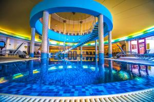 a swimming pool with a slide in a building at Hotel Kapitany Wellness in Sümeg