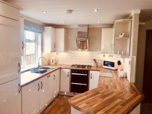 a kitchen with white cabinets and a stove top oven at The Lodges at Sapey Golf & Country Club in Upper Sapey