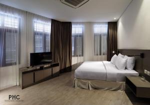 a bedroom with a bed and a flat screen tv at Magazine Vista Hotel by PHC in George Town