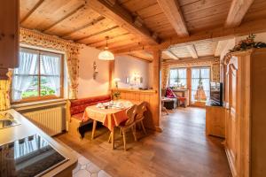 a kitchen and dining room with a table in a room at Ferienwohnungen Hollweger inkl. Chiemgaukarte in Ruhpolding
