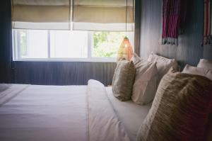 a bedroom with a white bed with a window at iRoHa Garden Hotel & Resort in Phnom Penh