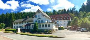 a large white building on the side of a road at Hotel Rodebachmühle in Georgenthal