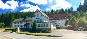 een groot wit gebouw aan de kant van een weg bij Hotel Rodebachmühle in Georgenthal