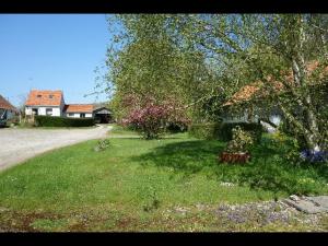 un patio con un árbol y flores en el césped en La Ferme De Tigny, en Tigny-Noyelle 12 fotos más