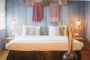 a bedroom with a large bed with white sheets at iRoHa Garden Hotel & Resort in Phnom Penh