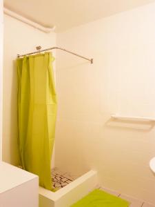 Un baño con ducha con cortina de ducha amarilla. en TI-COLO, en Sainte-Anne 24 fotos más
