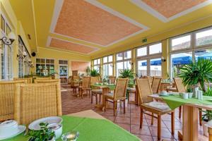 a restaurant with tables and chairs and windows at Alte Schleiferei in Breitenbrunn