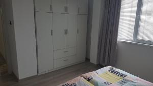 een slaapkamer met een witte kast en een bed bij Roza Apartment in Varna