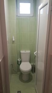 een kleine badkamer met een toilet en een raam bij Roza Apartment in Varna +12 foto's