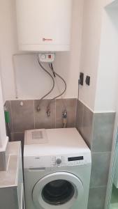 een wasmachine in een keuken met een witte kast bij Roza Apartment in Varna