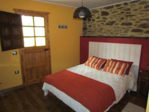 una camera con letto e muro di mattoni di CASA RURAL El Refugio del Poeta a Triufé