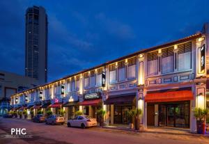 un edificio con coches estacionados en una calle por la noche en Ropewalk Piazza Hotel by PHC en George Town