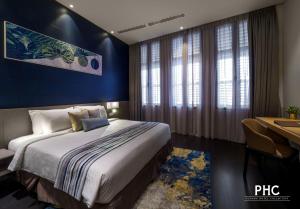 1 dormitorio con 1 cama con pared azul en Ropewalk Piazza Hotel by PHC en George Town