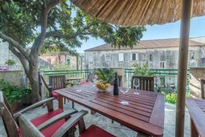a wooden table and chairs on a patio at Apartments Napoleon in Jelsa