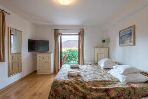 a bedroom with a large bed and a television at Apartments Napoleon in Jelsa