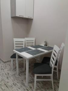 リヴィウにあるSkelnaia Apartmentの白いテーブル(椅子4脚付)と白いキャビネット