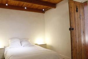 モンペリエにあるAppartement tout confort proche gare et centre villeの白いベッドと木製のドアが備わるベッドルーム1室が備わります。