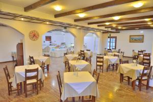 una sala da pranzo con tavoli e sedie bianchi di Elena Beach Hotel a Kíssamos