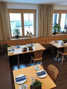 un comedor con mesas, sillas y ventanas en Arlenweg, en Sankt Anton am Arlberg