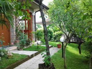 un jardin avec une maison arborée et une passerelle dans l'établissement B&B Il Rondò, à Sirmione