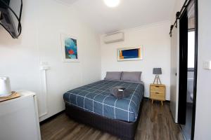 ein Schlafzimmer mit einem Bett in einem weißen Zimmer in der Unterkunft Latitude20 Roebourne Village in Roebourne