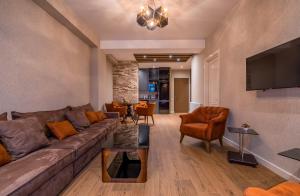 a living room with a couch and a tv at Premium Residence Tbilisi in Tbilisi City