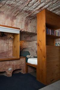a bedroom with a bed and a book shelf at Ali's Underground Studio in Coober Pedy