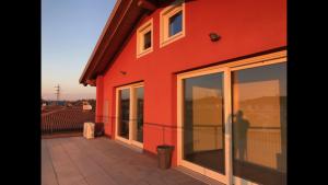ein rotes Gebäude mit Glasfenstern an der Seite in der Unterkunft Via Venezia Accomodating Solutions in Lonigo