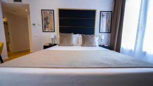 
a hotel room with a white bed and white walls at L&H Gran Vía Selection in Madrid
