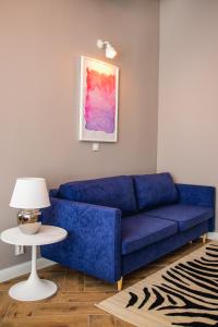 a blue couch in a living room with a table at W1 Katowice in Katowice