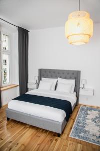 Un dormitorio con una gran cama blanca y una lámpara de araña. en W1 Katowice en Katowice