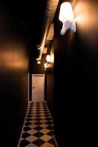 a dark hallway with a white door and a checkered floor at W1 Katowice in Katowice